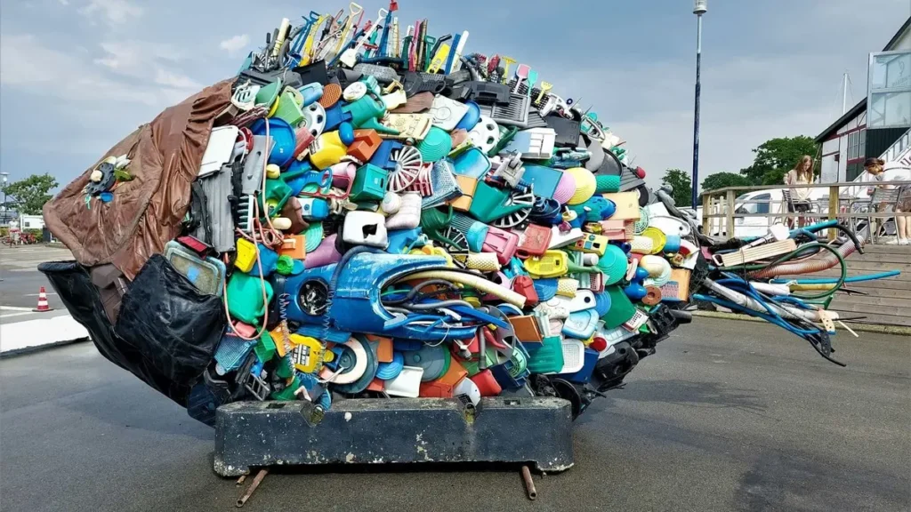 Sculpture en forme de poisson présente sur un éco-point réalisée avec des déchets récoltés sur la plage.